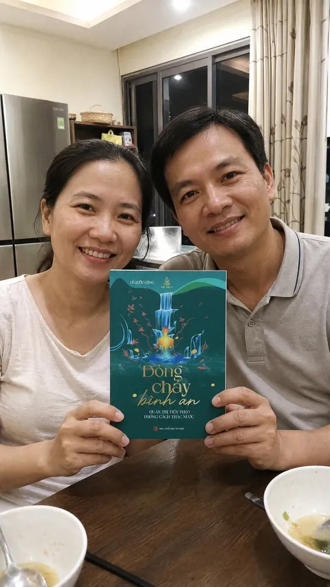 Hai vợ chồng cùng xem sách bên bàn ăn